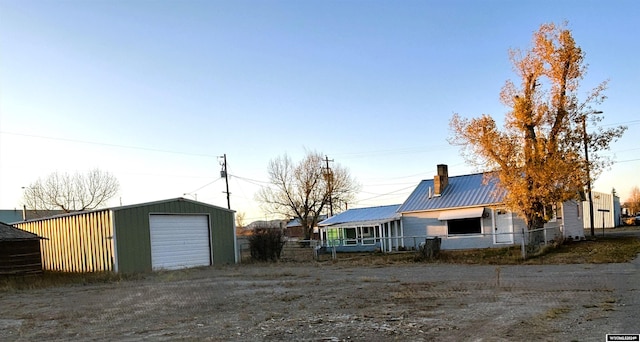 exterior space featuring a garage and an outbuilding