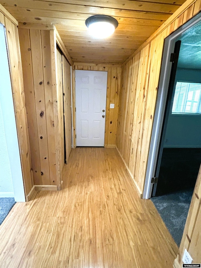 hallway with hardwood / wood-style flooring, wood ceiling, and wood walls