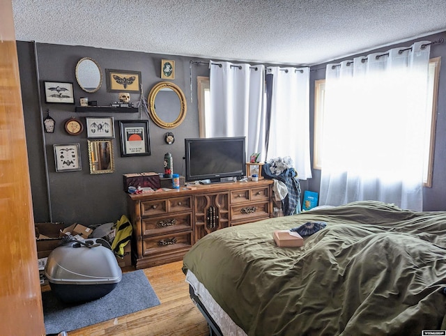 bedroom with hardwood / wood-style flooring and a textured ceiling