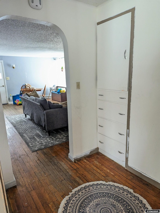 hall with dark hardwood / wood-style floors and a textured ceiling