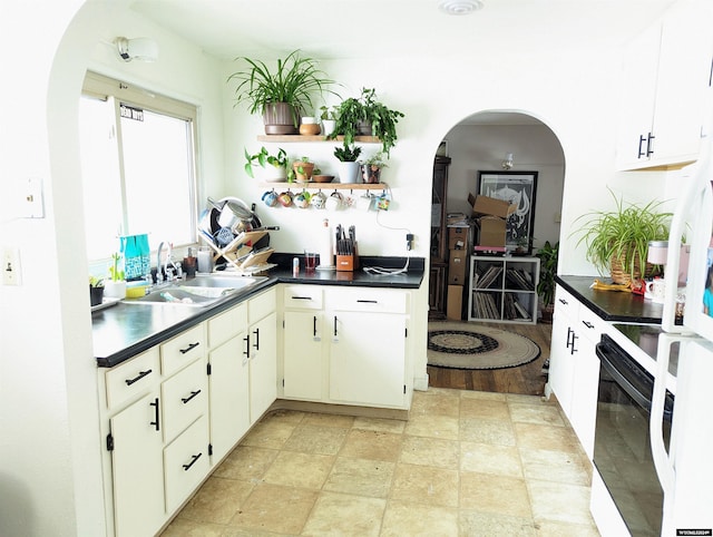 kitchen featuring white electric range, sink, light hardwood / wood-style floors, and white cabinets