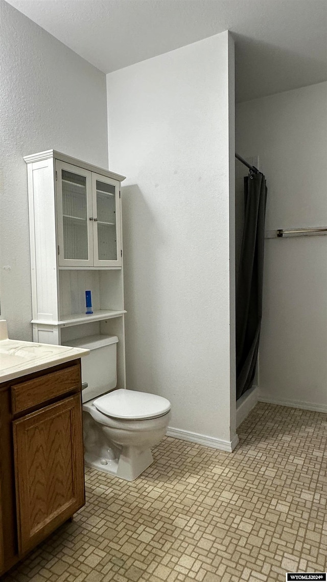 bathroom featuring toilet, a shower with curtain, and vanity