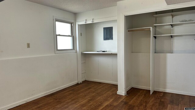 unfurnished bedroom featuring a closet, a textured ceiling, and dark hardwood / wood-style flooring