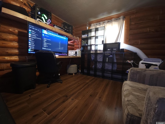 office with a textured ceiling, hardwood / wood-style flooring, and rustic walls