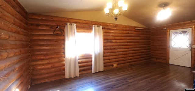 spare room featuring rustic walls, lofted ceiling, a notable chandelier, and dark hardwood / wood-style floors