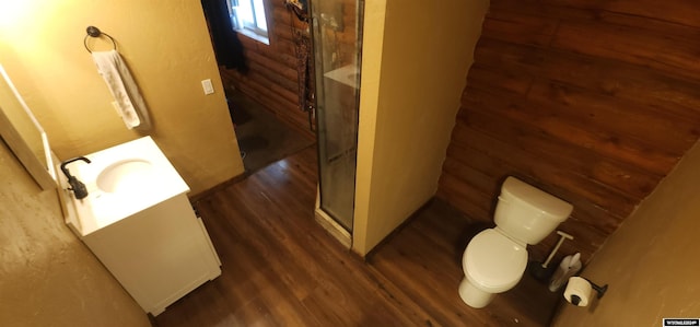 bathroom with toilet, hardwood / wood-style floors, vanity, and a shower