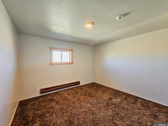 carpeted spare room with baseboard heating and a textured ceiling