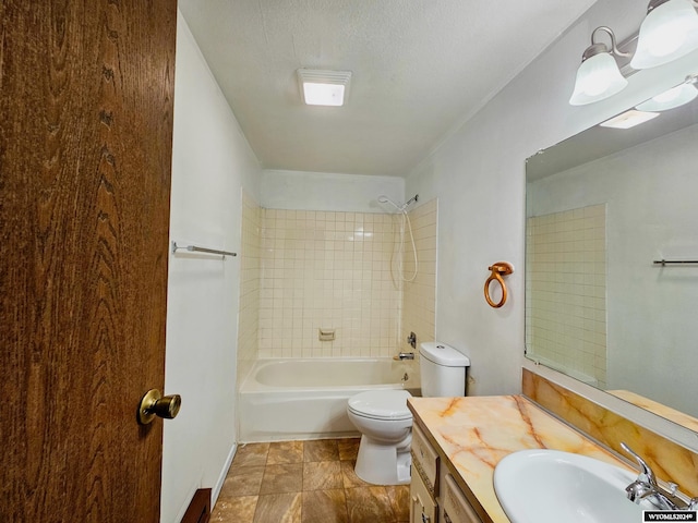 full bathroom featuring tiled shower / bath, vanity, and toilet