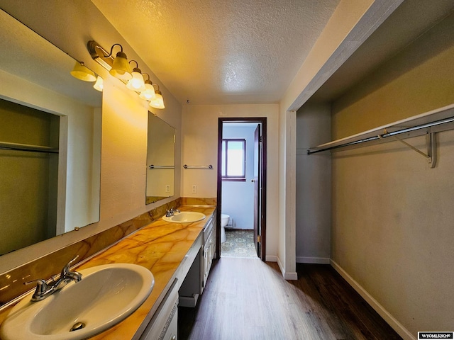 bathroom with vanity, a textured ceiling, and hardwood / wood-style flooring