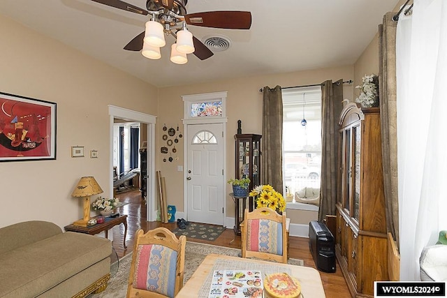 foyer entrance with a wealth of natural light, hardwood / wood-style flooring, and ceiling fan