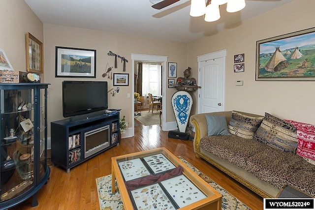 living room featuring hardwood / wood-style floors and ceiling fan