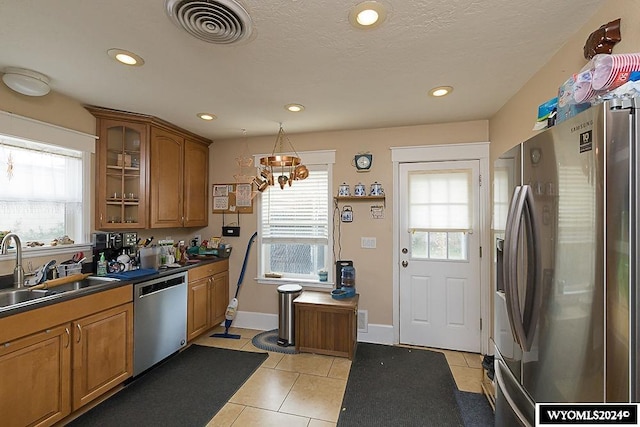 kitchen with a healthy amount of sunlight, light tile patterned floors, stainless steel appliances, and sink