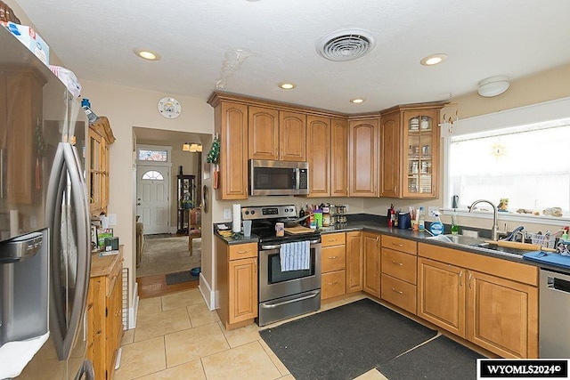 kitchen featuring sink, appliances with stainless steel finishes, a textured ceiling, and light tile patterned flooring