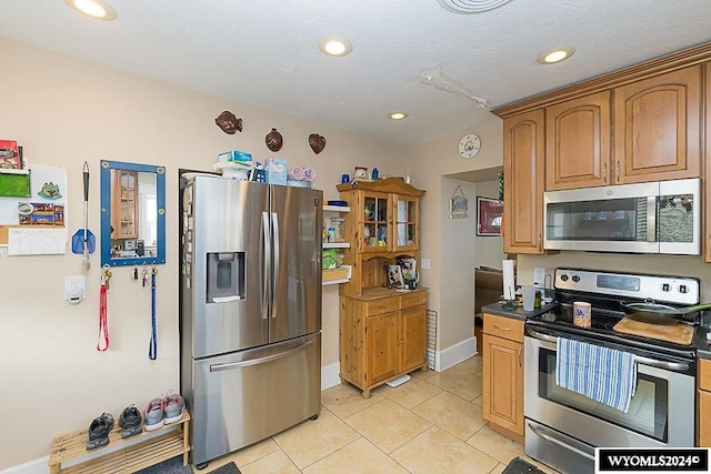 kitchen with appliances with stainless steel finishes and light tile patterned flooring