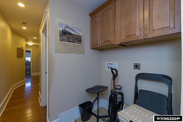 laundry area featuring hookup for an electric dryer, hookup for a washing machine, dark hardwood / wood-style floors, and cabinets