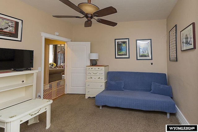 sitting room featuring dark colored carpet and ceiling fan