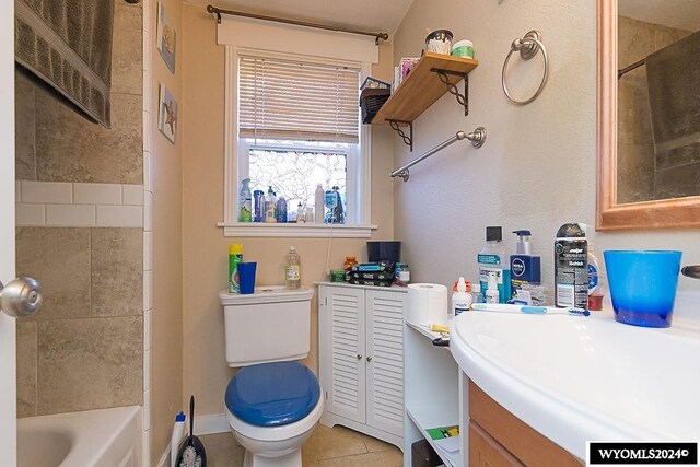 full bathroom with vanity, tiled shower / bath combo, toilet, and tile patterned floors