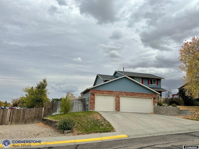 traditional home featuring brick siding, fence, driveway, and an attached garage