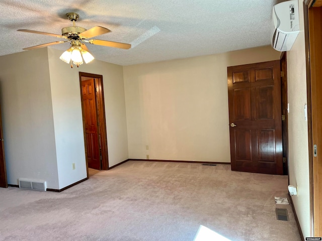 spare room featuring light carpet, a textured ceiling, and ceiling fan