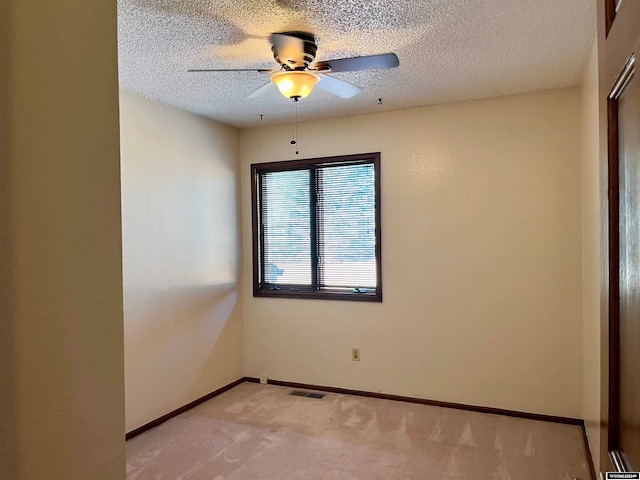 empty room with light carpet, a textured ceiling, and ceiling fan