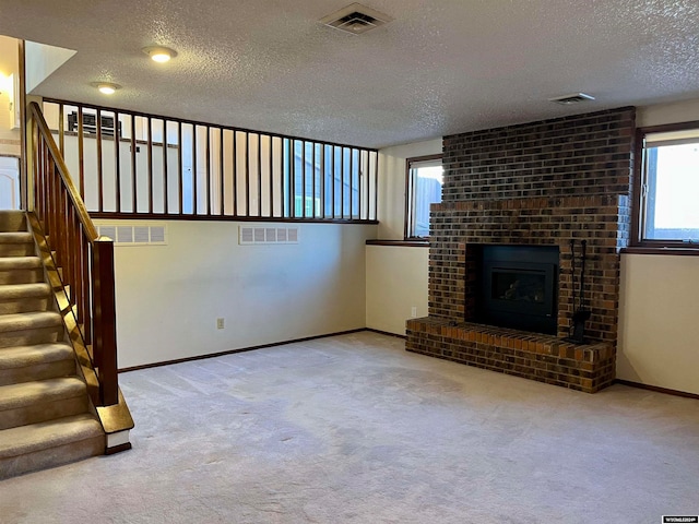 unfurnished living room featuring a fireplace, a textured ceiling, and light colored carpet