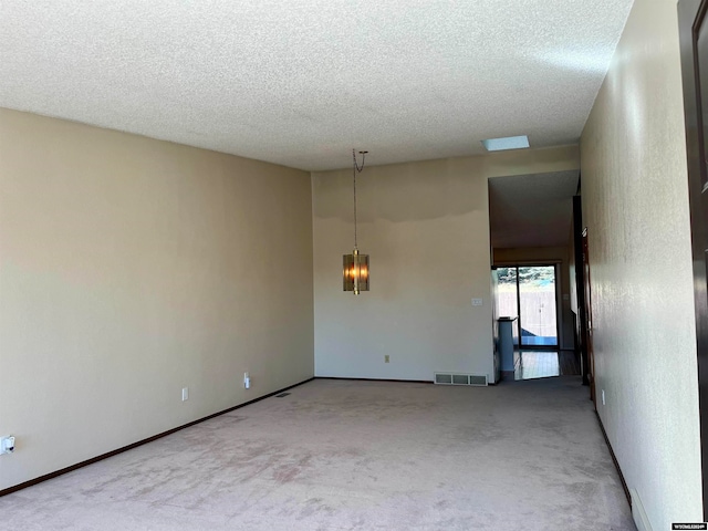 empty room featuring carpet and a textured ceiling