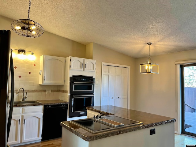 kitchen with white cabinetry, black appliances, decorative light fixtures, and sink