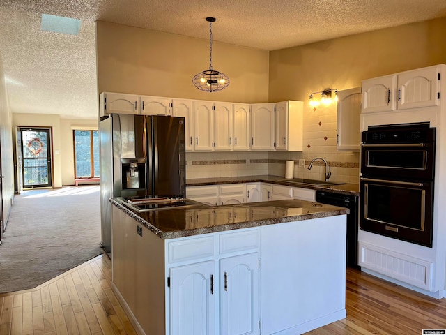 kitchen featuring white cabinetry, black appliances, sink, and decorative light fixtures