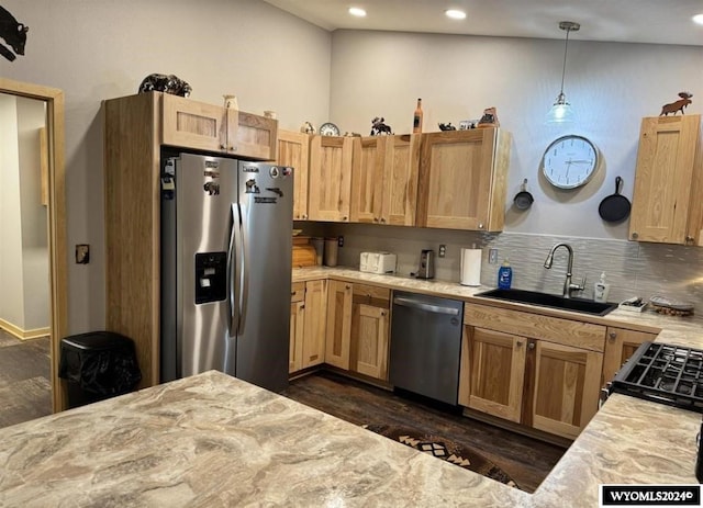 kitchen with lofted ceiling, hanging light fixtures, backsplash, sink, and appliances with stainless steel finishes