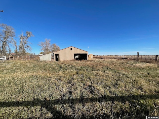 view of yard with a rural view and an outdoor structure