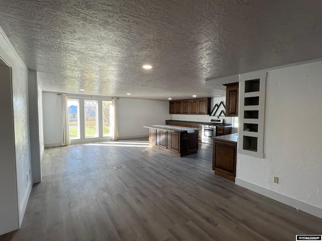 kitchen with a kitchen island, a textured ceiling, wood-type flooring, and electric stove