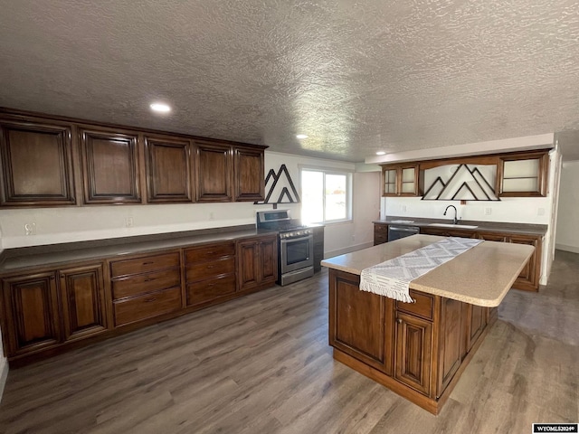 kitchen with a kitchen island, a textured ceiling, hardwood / wood-style flooring, sink, and stainless steel appliances