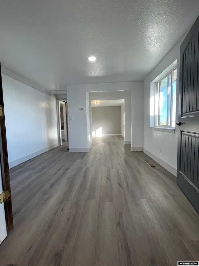 unfurnished living room featuring a textured ceiling and hardwood / wood-style flooring