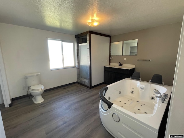 full bathroom with shower with separate bathtub, a textured ceiling, hardwood / wood-style floors, toilet, and vanity