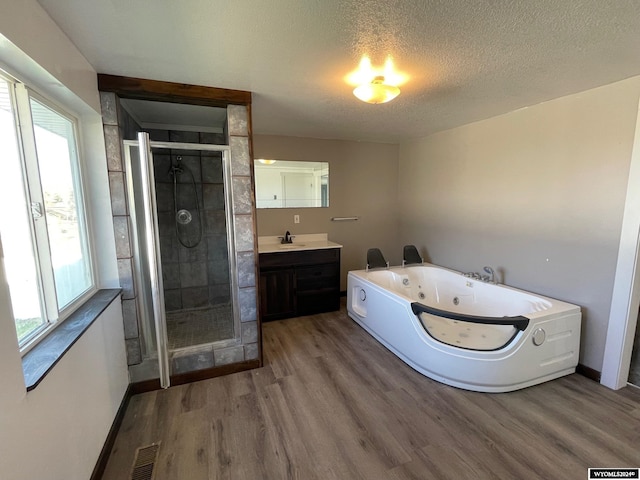 bathroom featuring vanity, a textured ceiling, separate shower and tub, and hardwood / wood-style flooring