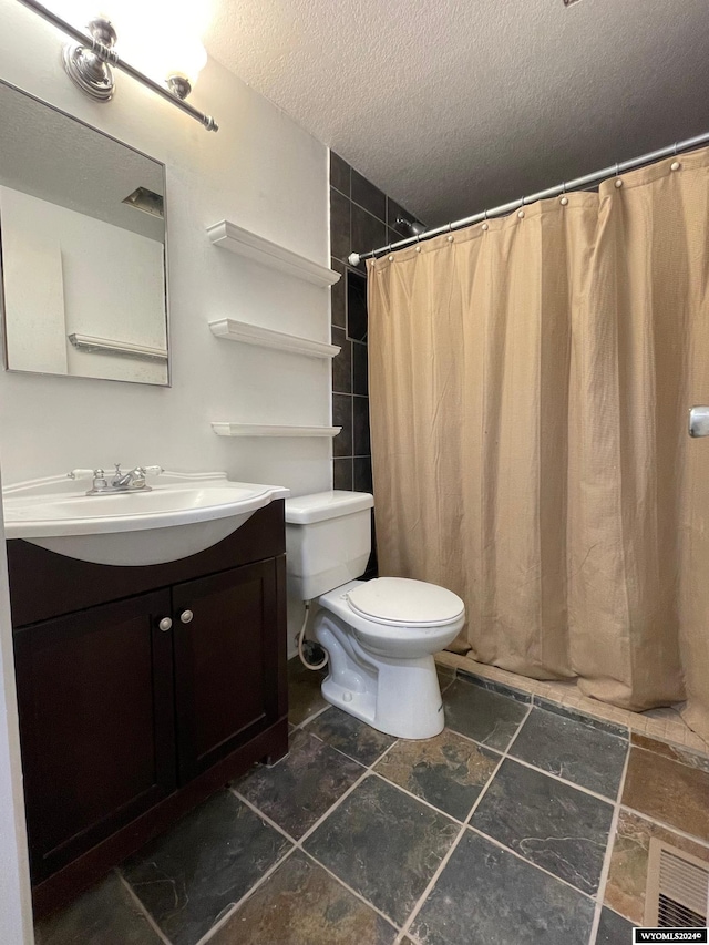 bathroom with vanity, toilet, a textured ceiling, and a shower with curtain