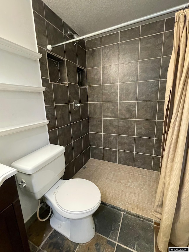 bathroom with toilet, a textured ceiling, walk in shower, and vanity