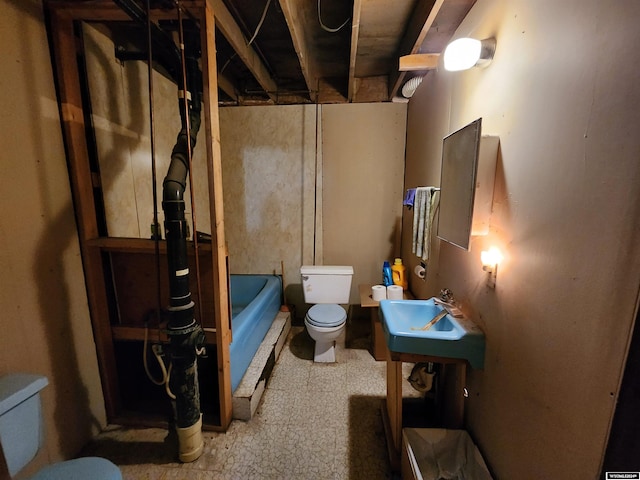 bathroom featuring toilet, a tub, and sink