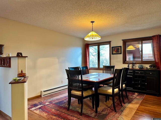 36 County Road 211, Riverside, WY 82325 - dining space with a textured ceiling, a baseboard radiator, and dark hardwood / wood-style flooring