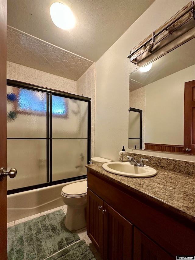 36 County Road 211, Riverside, WY 82325 - full bathroom featuring a textured ceiling, toilet, enclosed tub / shower combo, tile patterned floors, and vanity