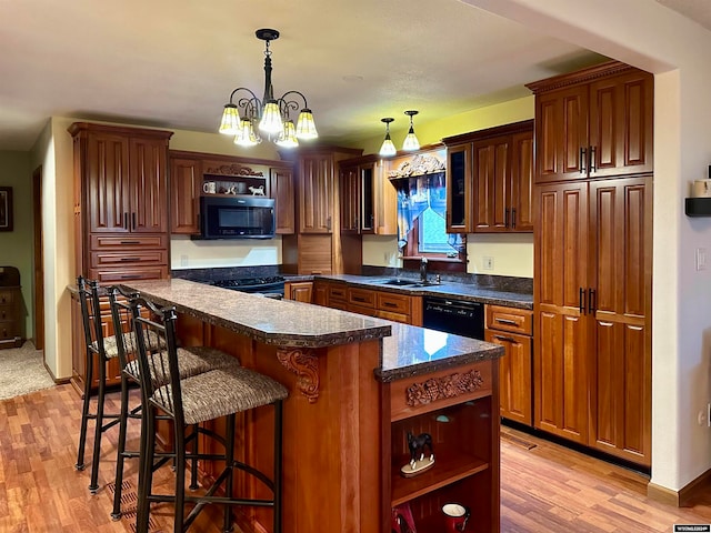 36 County Road 211, Riverside, WY 82325 - kitchen featuring black appliances, sink, light wood-type flooring, a kitchen island, and an inviting chandelier