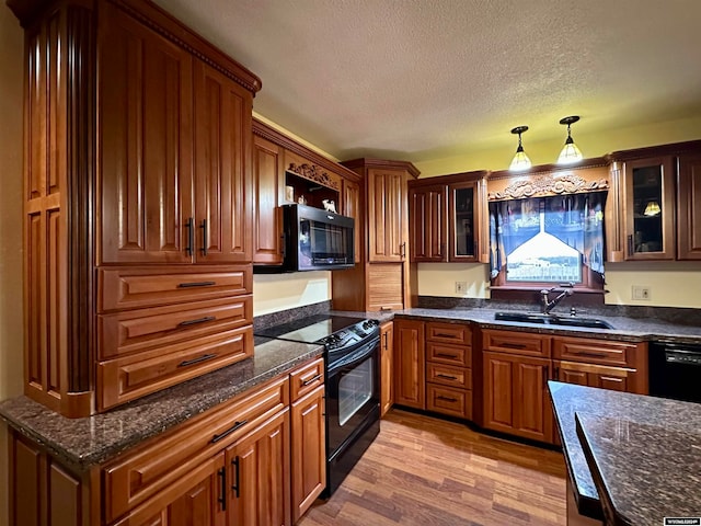 36 County Road 211, Riverside, WY 82325 - kitchen featuring a textured ceiling, light wood-type flooring, black appliances, pendant lighting, and sink