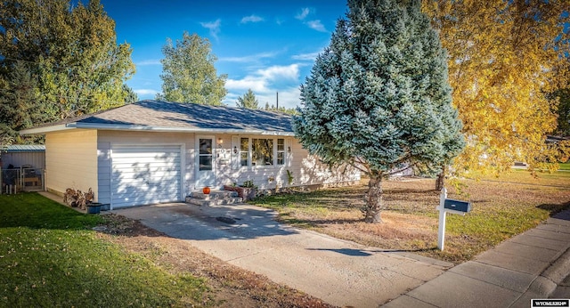 single story home featuring a garage and a front lawn