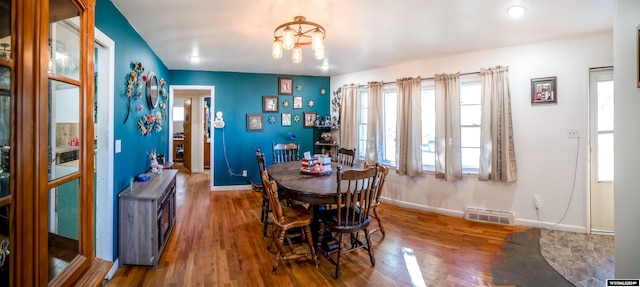 dining area featuring an inviting chandelier and hardwood / wood-style floors