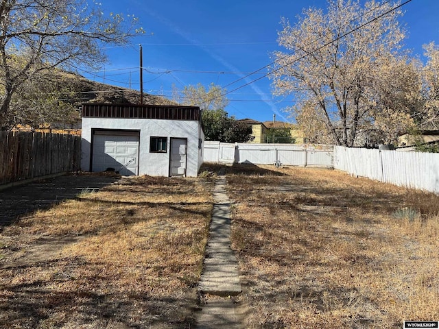 view of yard featuring a garage and an outbuilding