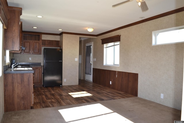 kitchen with extractor fan, dark wood-type flooring, black refrigerator, ornamental molding, and ceiling fan