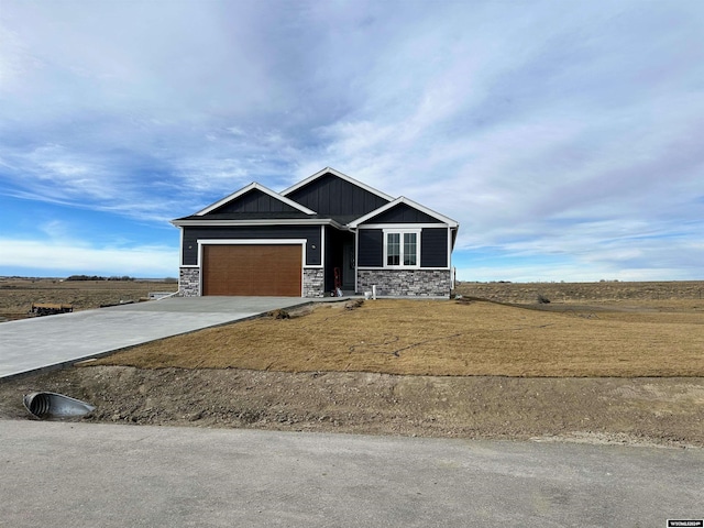 view of front of home featuring stone siding, board and batten siding, concrete driveway, and an attached garage