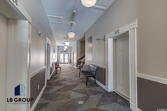 corridor featuring dark colored carpet