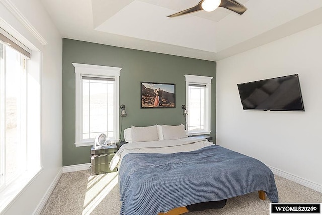 21 Branding Iron Dr, Green River, WY 82935 - carpeted bedroom featuring multiple windows, baseboards, a ceiling fan, and a raised ceiling