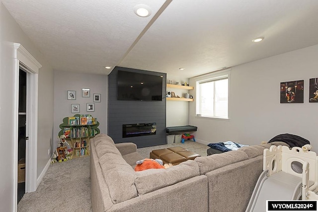 carpeted living room with a textured ceiling and a fireplace